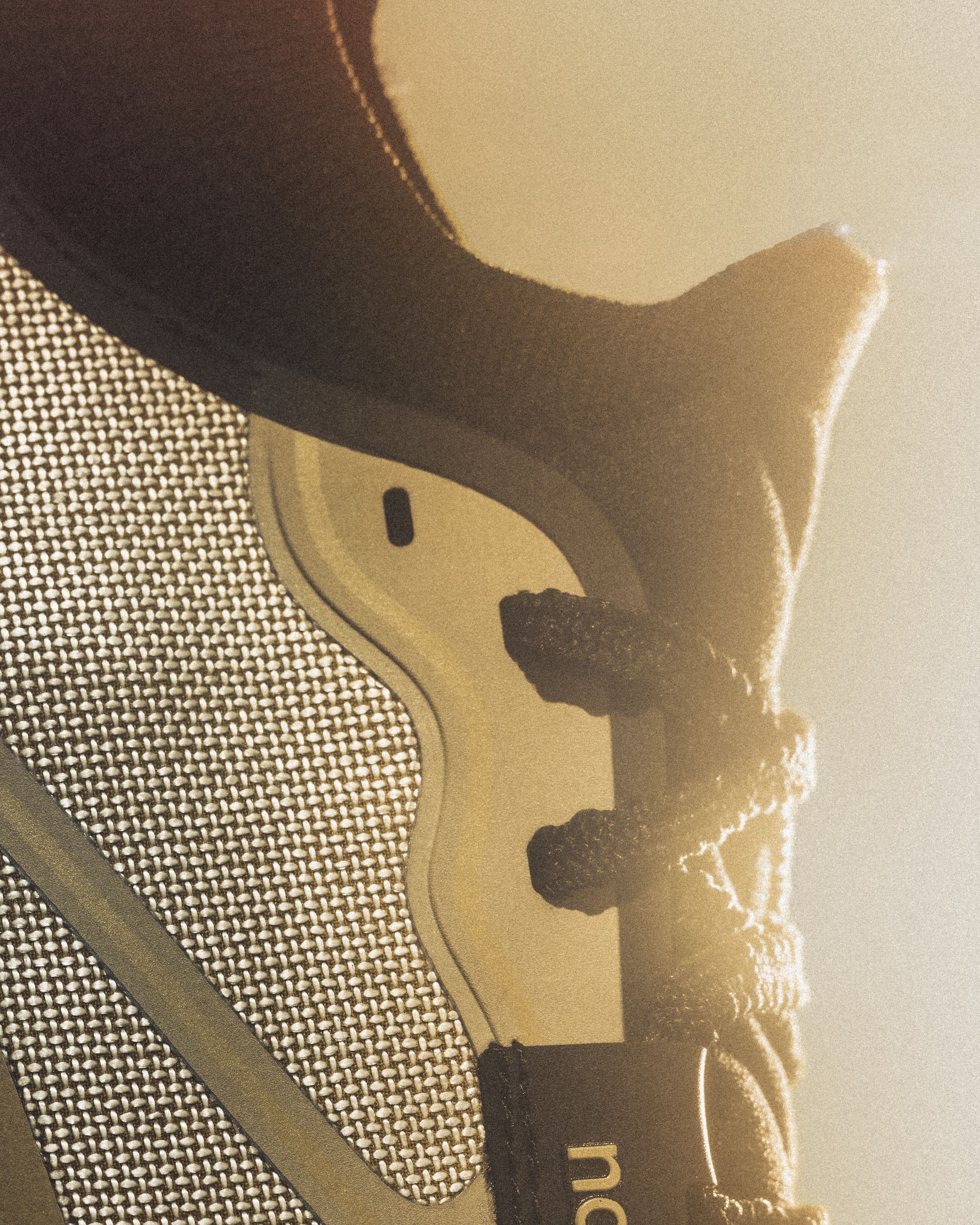 Macro detail of the 055's woven Dyneema upper, lace loops and knit collar