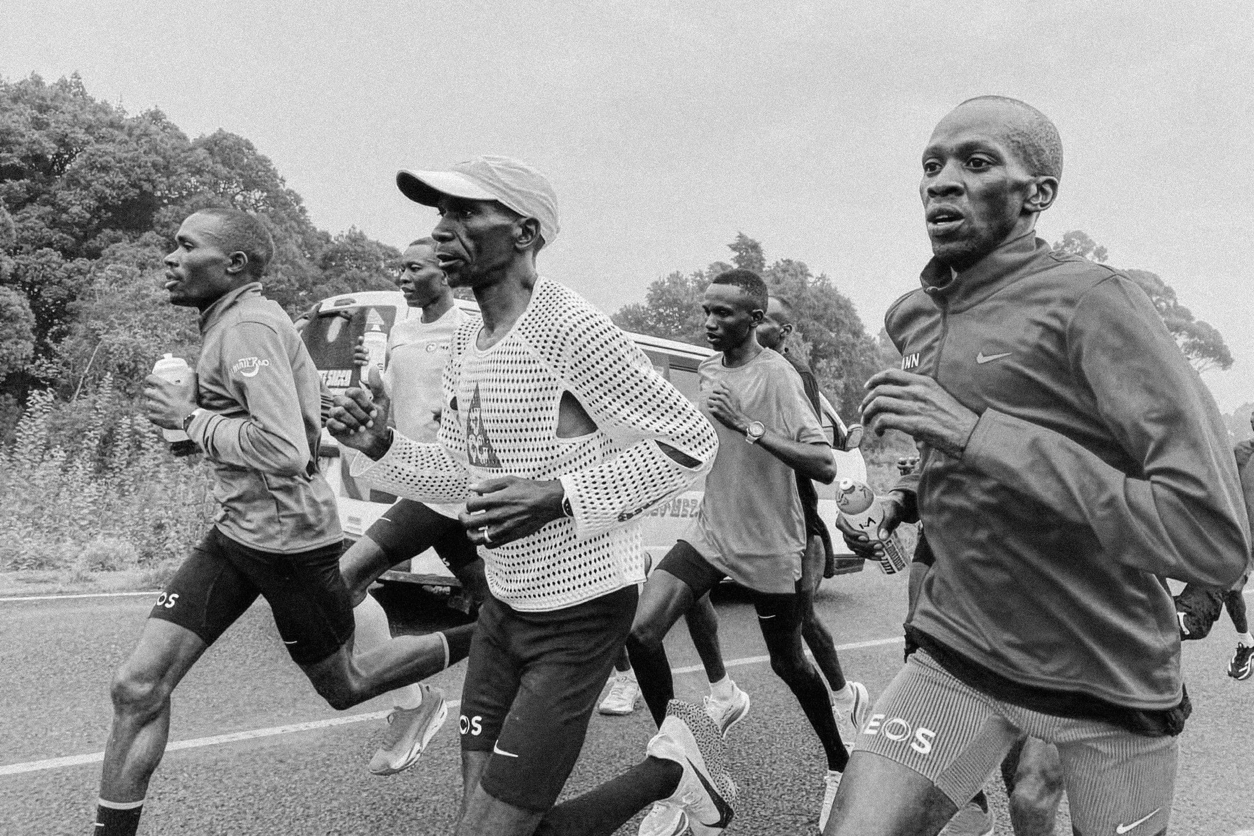 Eliud Kipchoge training on a road in Kenya with his group, in a white Radical AirFlow top, black and white