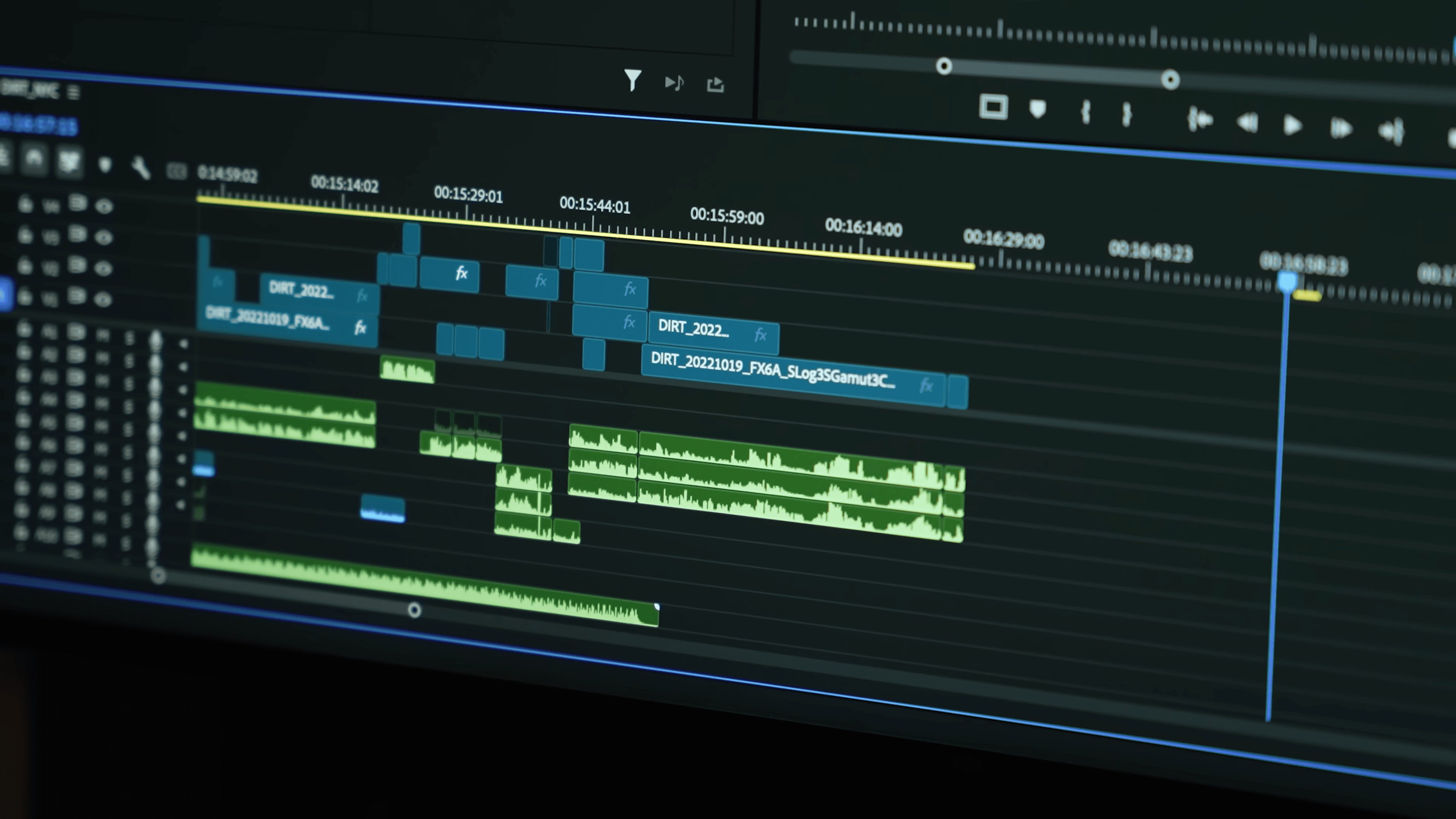 An editing timeline on a monitor, stacked with DIRT clips and audio tracks
