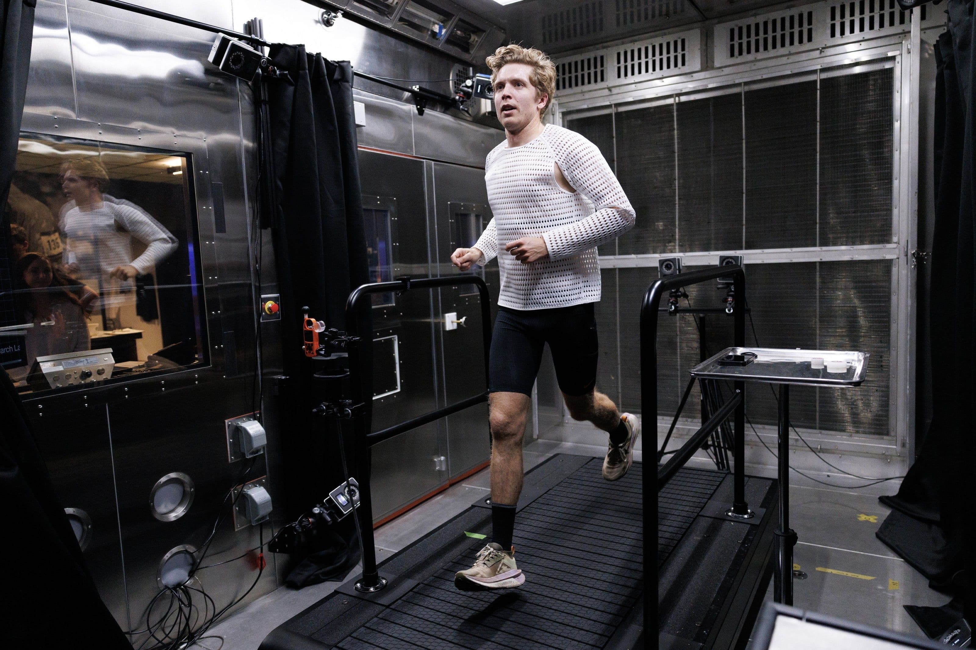 Drew Holmen running on a treadmill inside the Nike Sport Research Lab climate chamber, in a white Radical AirFlow prototype