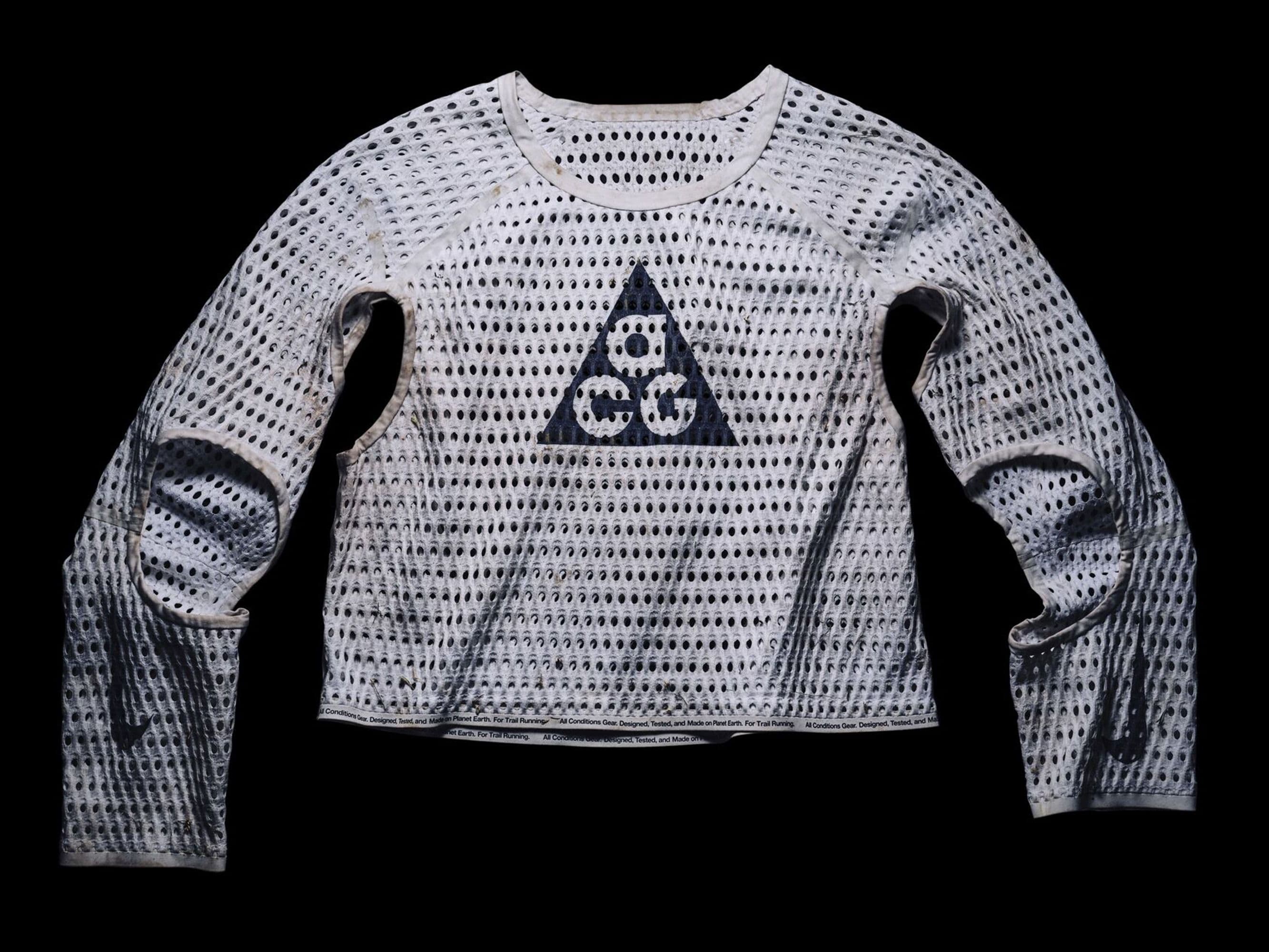Caleb Olson’s race-worn white Radical AirFlow prototype laid flat on black, ACG triangle on the chest, elbows and underarms cut open